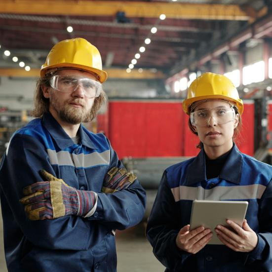 To ingeniører i arbejdstøj og sikkerhedshjelme