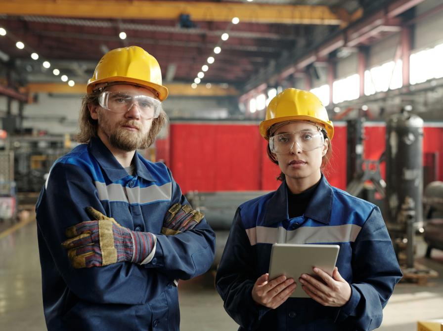 To ingeniører i arbejdstøj og sikkerhedshjelme